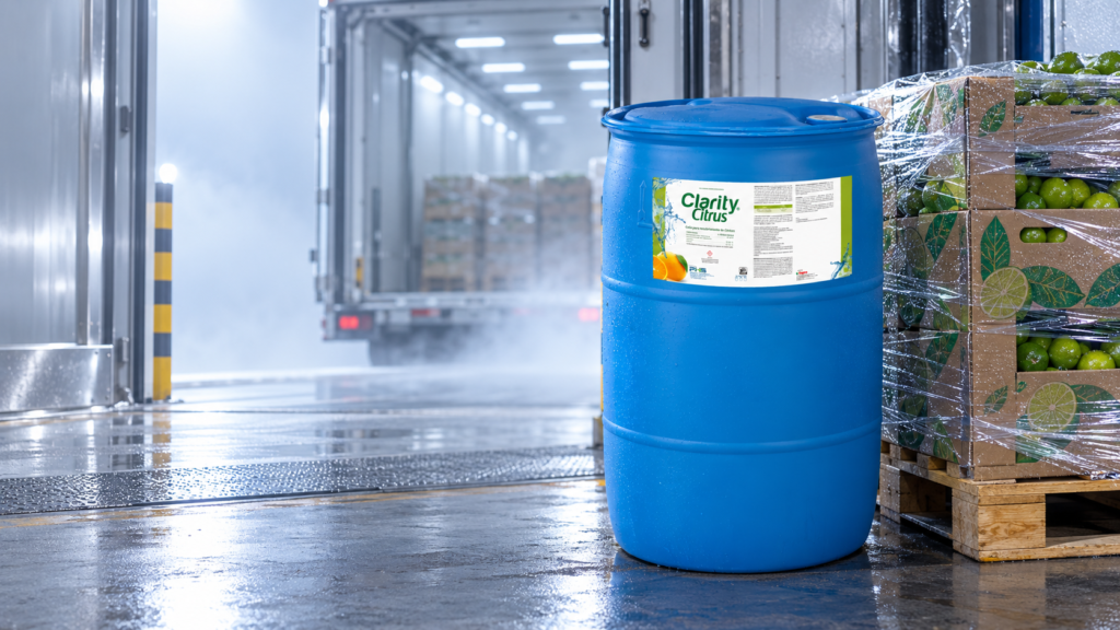 Tambo de 200 L de Clarity Citrus, cera para cítricos de exportación, junto a un pallet de cajas de limón en cuarto frío